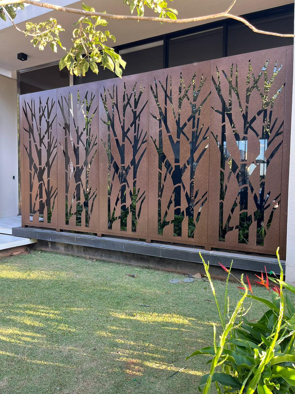 Painéis de tonalidade corten com desenho inspirado em galhos em uma residência